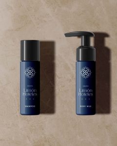Botellas de amenities personalizados con el logotipo de Grupo Limón Hoteles sobre fondo de mármol.