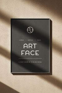 Cartel con fondo negro y logotipo de Art Face iluminado por sombras naturales.