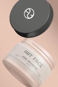Diseño de packaging para crema facial Art Face, con isotipo elegante sobre fondo rosado.