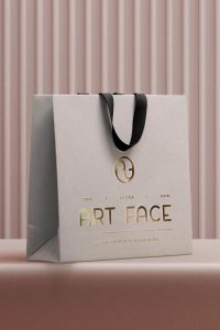 Bolsa de papel con el logotipo de Art Face impreso en dorado metalizado
