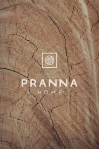Logotipo de Pranna Home aplicado sobre textura de madera, parte del branding artesanal diseñado por Manawa Creative.