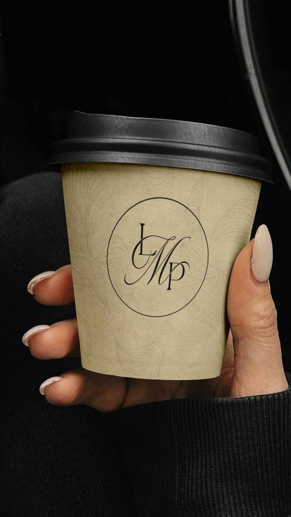 Vaso de café con el isotipo LMP de Lycaste Marketing Partners aplicado sobre textura botánica, diseño de Manawa Creative.