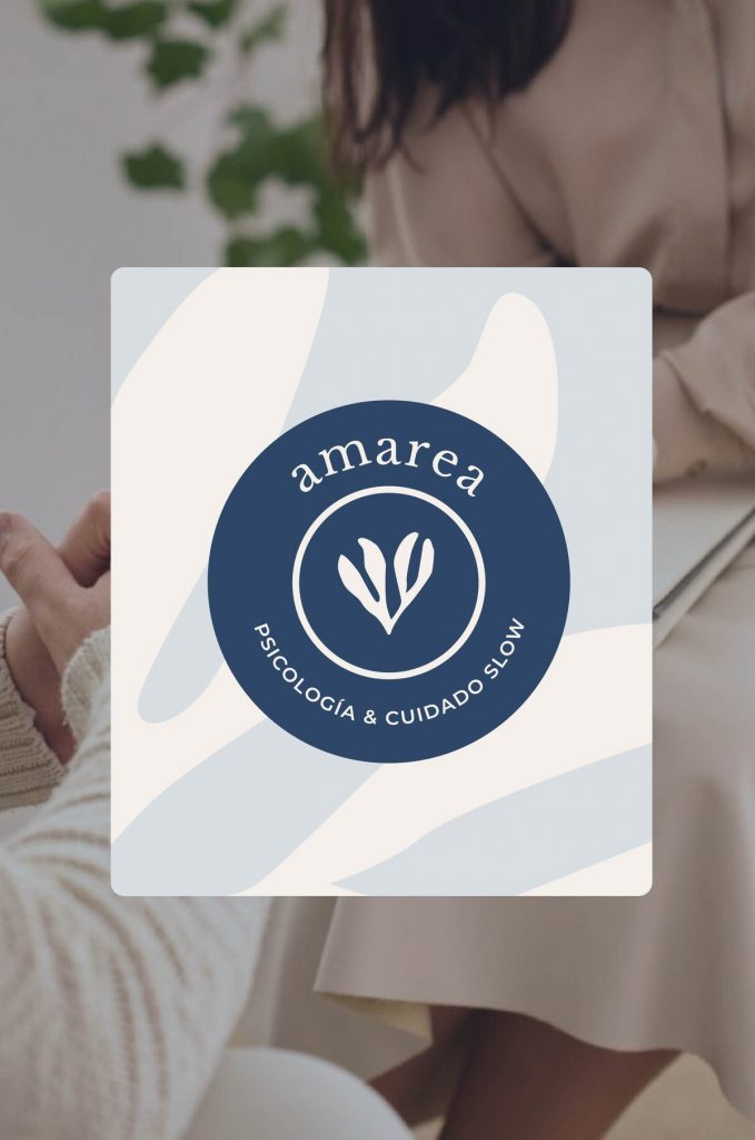 Primer plano de una mano sosteniendo la insignia circular con el isotipo de Amarea